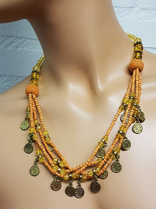 Ketting met zacht oranje kralen en oude muntjes