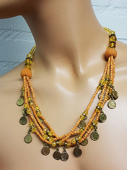 Ketting met zacht oranje kralen en oude muntjes